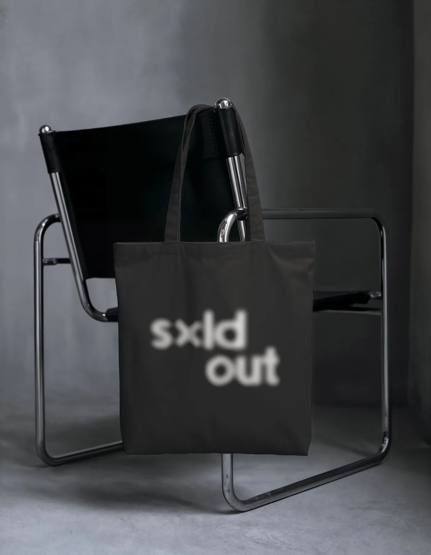 Tote bag negra con «sxld out» desenfocado